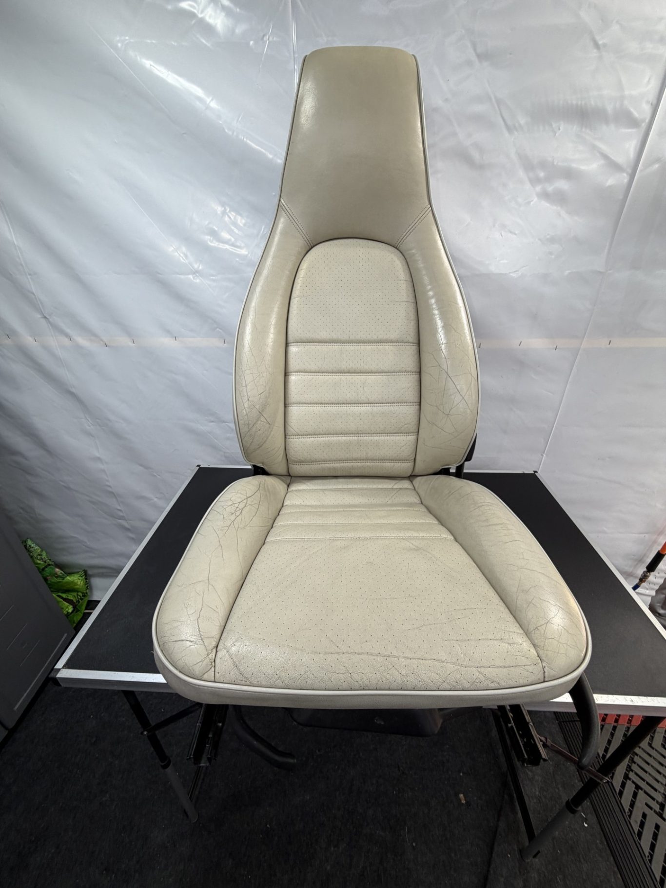 AVANT Un siège de voiture en cuir beige avec un dossier haut et un design épuré.