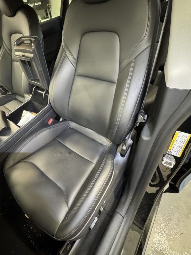 Siège auto en cuir noir, avec un design élégant et confortable.