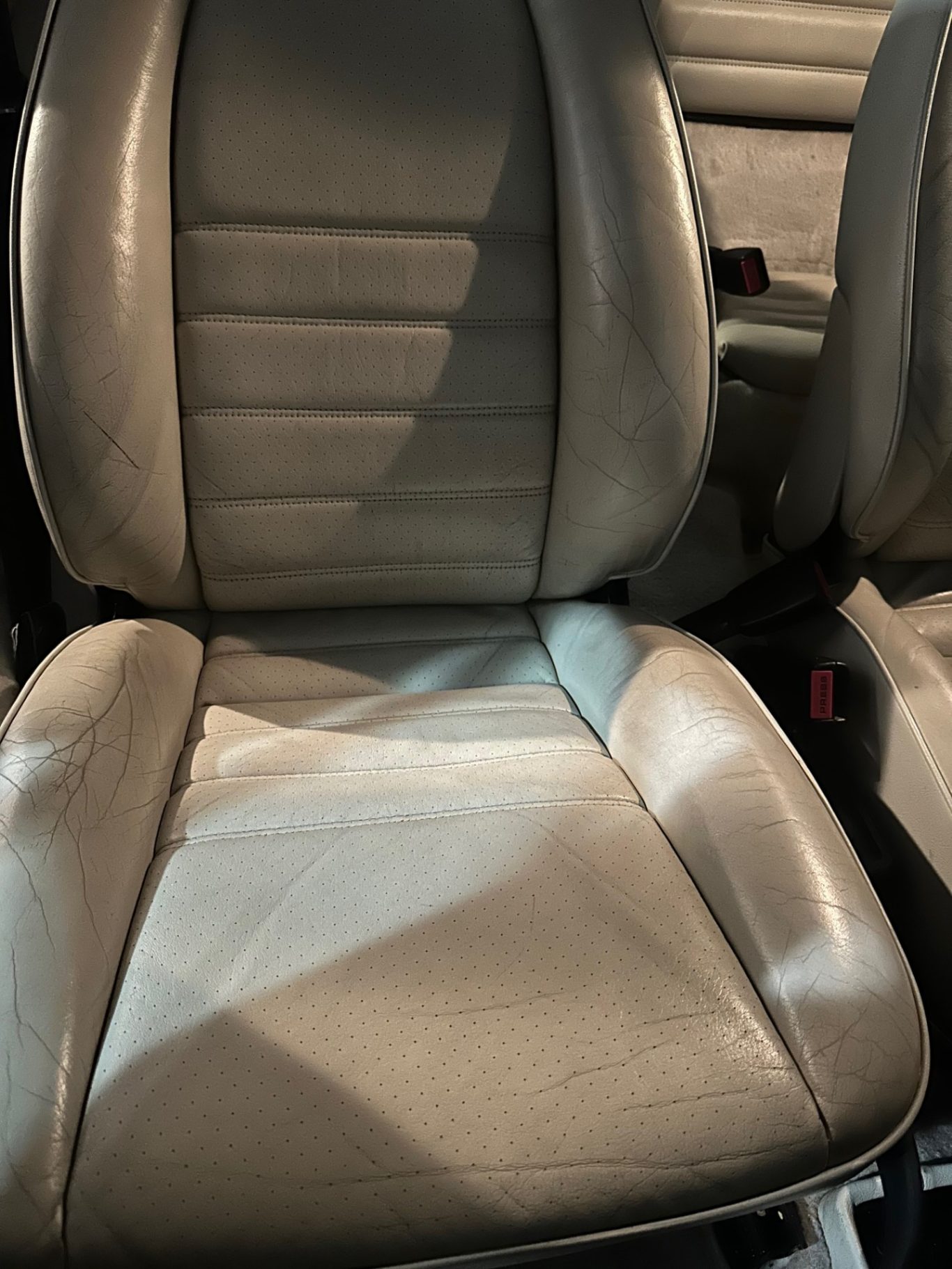 AVANT Siège de voiture en cuir beige, sans occupant, avec des coutures visibles.