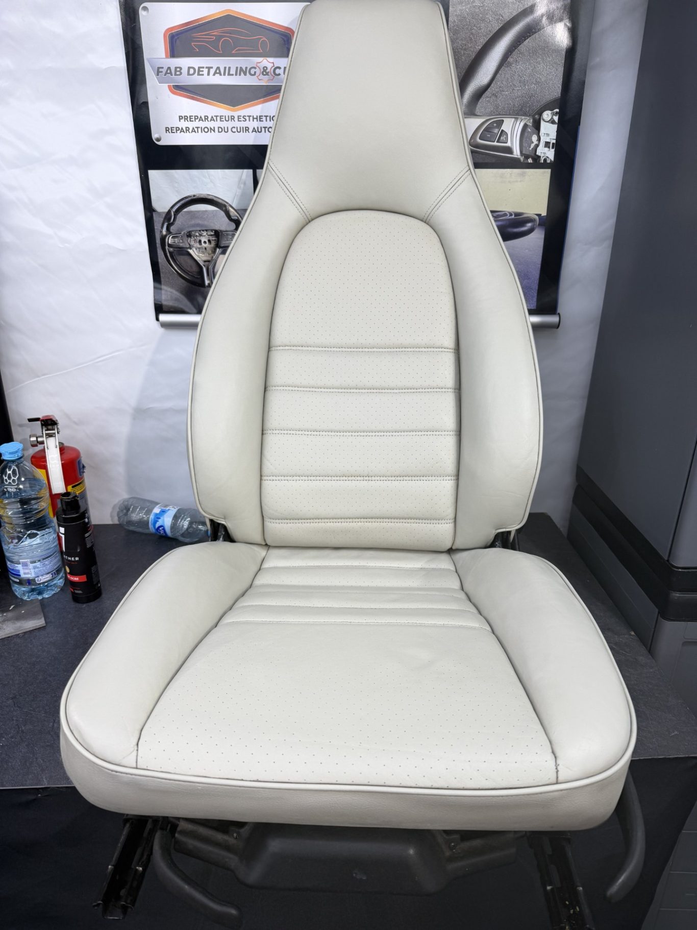 APRES Siège auto en cuir beige, avec des coutures sur le dossier et l'assise.
